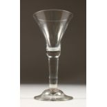 A LARGE 18TH CENTURY WINE GLASS, with inverted bell shaped bowl and plain stem. 7ins high.