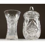A CUT GLASS JAR AND COVER, and a similar vase. 10ins and 8ins high.