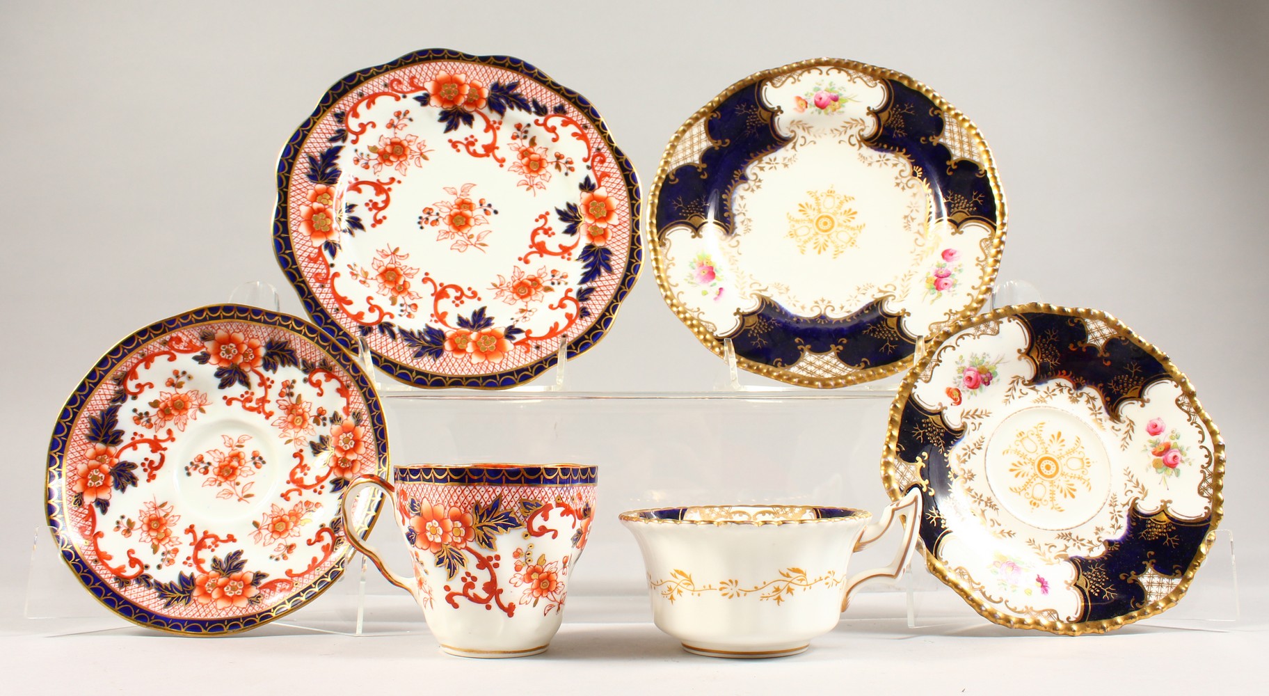 A COALPORT TRIO AND A HAMMERSLEY TRIO, blue and gilt painted with roses.