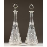 A PAIR OF CUT GLASS TAPERING DECANTERS. 14ins high.