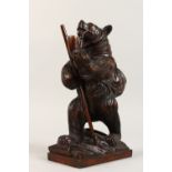 A BLACK FOREST STYLE CARVING of a bear smoking a pipe. 12ins high.