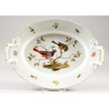 A BERLIN TWO HANDLED OVAL DISH, painted with birds. 14ins long.