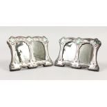 A PAIR OF ART NOUVEAU STYLE SILVER DOUBLE PHOTO FRAMES, with enamel decoration. 4.5ins wide.