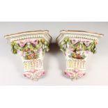 A PAIR OF MEISSEN STYLE PORCELAIN WALL BRACKETS, decorated with figures, flowers and bows. 9ins