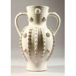 A 20TH CENTURY CONTINENTAL WHITE GLAZED TWIN HANDLED EARTHENWARE VASE, with ribbed decoration. 13ins