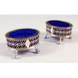 A PAIR OF OLD SHEFFIELD PLATE PIERCED SALTS with blue glass liners. 3.25ins wide.