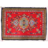 A SMALL PERSIAN RUG, red ground with floral decoration. 3ft 2ins x 2ft 4ins.