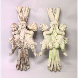 A PAIR OF CARVED WOOD AND PAINTED CUPIDS holding curtain ties. 4ft high x 1ft 7ins wide.
