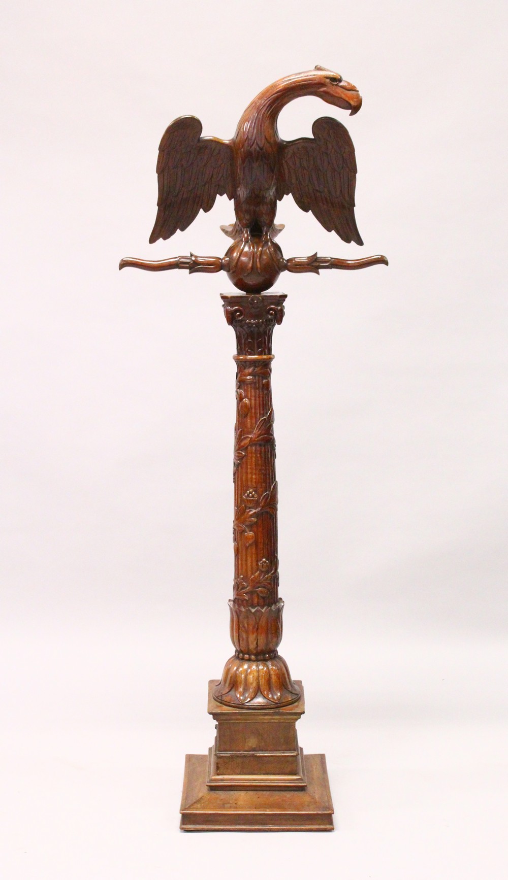 A 19TH CENTURY CARVED FRUITWOOD LECTURN, the book support carved as an eagle with outswept wings