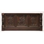 AN 18TH CENTURY STYLE OAK PANEL with three panels carved with men playing makeshift musical