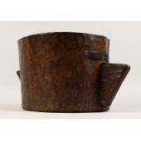 AN EARLY TWIN HANDLED MORTAR, carved from one piece of wood. 17ins wide x 8ins high.
