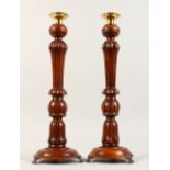 A PAIR OF TURNED WOOD CANDLESTICKS. 17ins high.