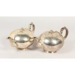 A PAIR OF SILVER TEAPOTS of rounded form, with melon finials, London 1861. Maker EB & JB. 50ozs.