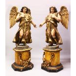 A LARGE PAIR OF CARVED, PAINTED AND GILDED FIGURES OF STANDING ANGELS, supported on faux marble