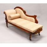 A VICTORIAN MAHOGANY FRAMED CHAISE LONGUE, with carved show wood frame, on turned legs. 6ft 0ins