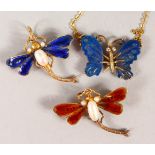 TWO GOLD AND ENAMEL DRAGONFLY PENDANTS / BROOCHES, and a butterfly pendant with chain.