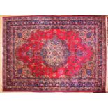 A MESHED CARPET, all over design in red and blue with a large central motif. 9ft 6ins x 6ft 8ins.