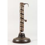 AN EARLY CANDLESTICK on a circular wooden base. 9.5ins high.
