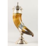 AN IMPRESSIVE HORN CUP, with ornate mounts, the cover with a lion finial. 18ins high.