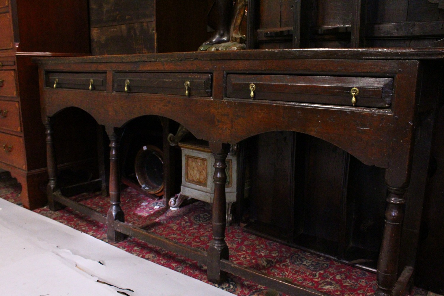 AN EARLY 17TH CENTURY OAK DRESSER, the upper section with shaped pelmet, and two shelves, the twin - Image 4 of 6