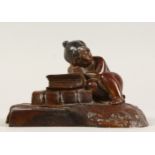 A SMALL CAST METAL GROUP, of a young girl sleeping by some books. 5ins wide.