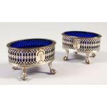 A PAIR OF OLD SHEFFIELD PLATE PIERCED SALTS with blue glass liners. 3ins wide.