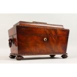 A VICTORIAN MAHOGANY SARCOPHAGUS SHAPED TEA CADDY with carved decoration, ring handles, the interior