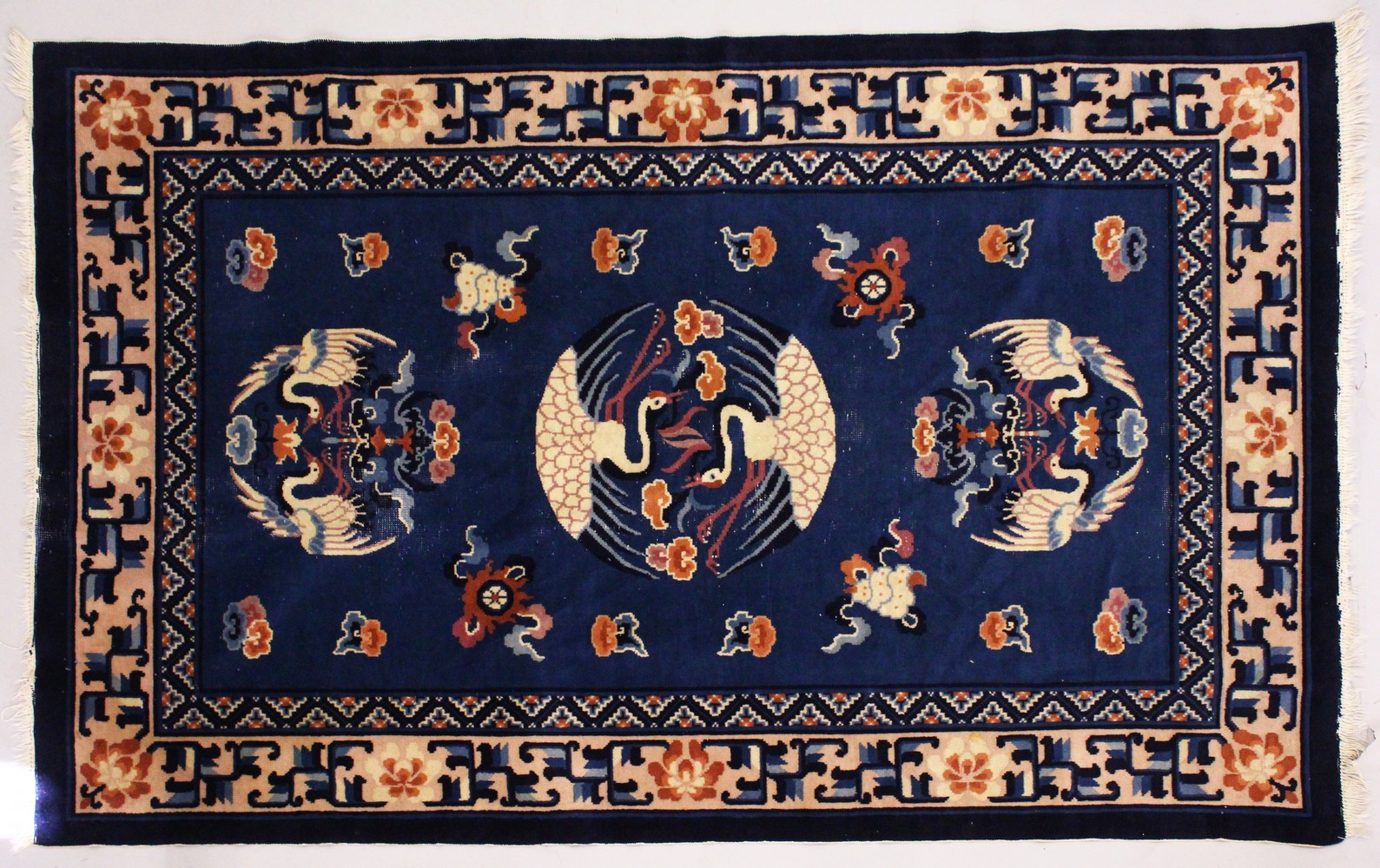 A SMALL CHINESE CARPET, with blue ground, with design of storks. 6ft 9ins x 4ft 4ins.