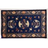 A SMALL CHINESE CARPET, with blue ground, with design of storks. 6ft 9ins x 4ft 4ins.