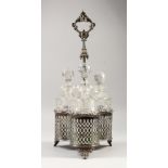 A TANTALUS, with ornate cast handles, pierced sides, containing three cut glass decanters. 18ins