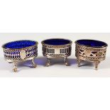 THREE OLD SHEFFIELD PLATE PIERCED SALTS with blue glass liners. 3ins and 2.75ins wide.
