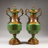 A PAIR OF SEVRES STYLE ORMOLU MOUNTED VASES AND COVERS, green ground, decorated with flowers.