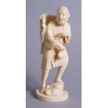 A GOOD QUALITY JAPANESE IVORY OKIMONO, a smoking man with his foot upon a rock, Meiji period, signed