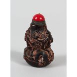 A CHINESE CARVED WOODEN SNUFF BOTTLR, in the shape of a double gourd, decorated with fruiting, red