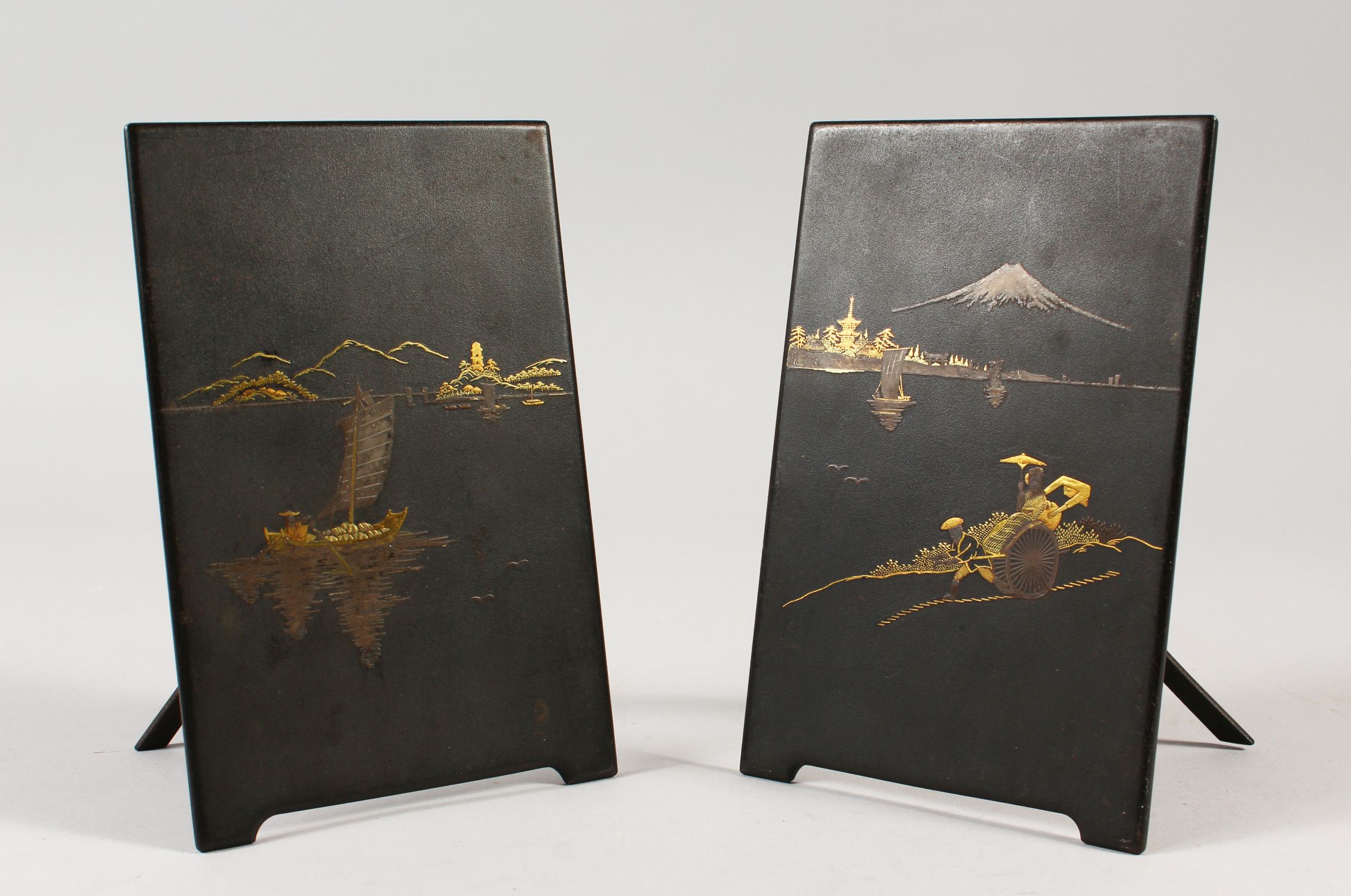 PAIR OF DAMASCENED IRON PLAQUES IN THE KOMAI STYLE, finely decorated with traditional scenes, with