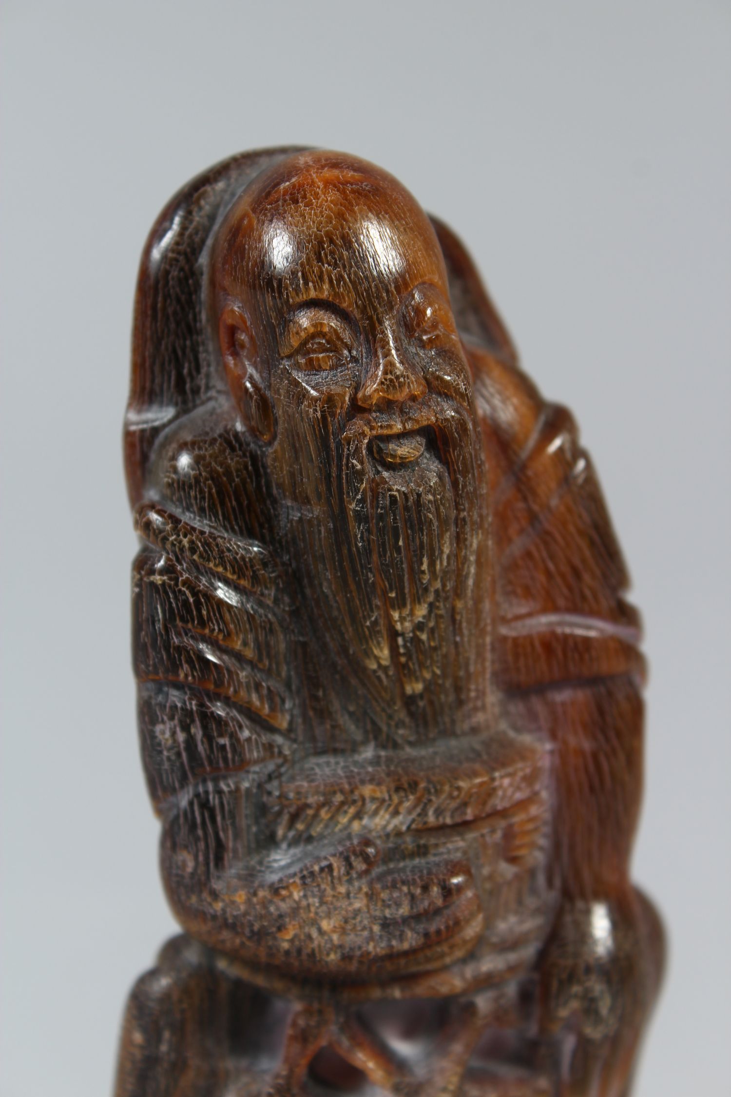 A CHINESE CARVED HORN FISHERMAN FIGURINE, seated upon a rocky outcrop, 11 cm high 5.5 cm wide. - Image 3 of 4