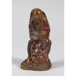 A CHINESE CARVED HORN FISHERMAN FIGURINE, seated upon a rocky outcrop, 11 cm high 5.5 cm wide.