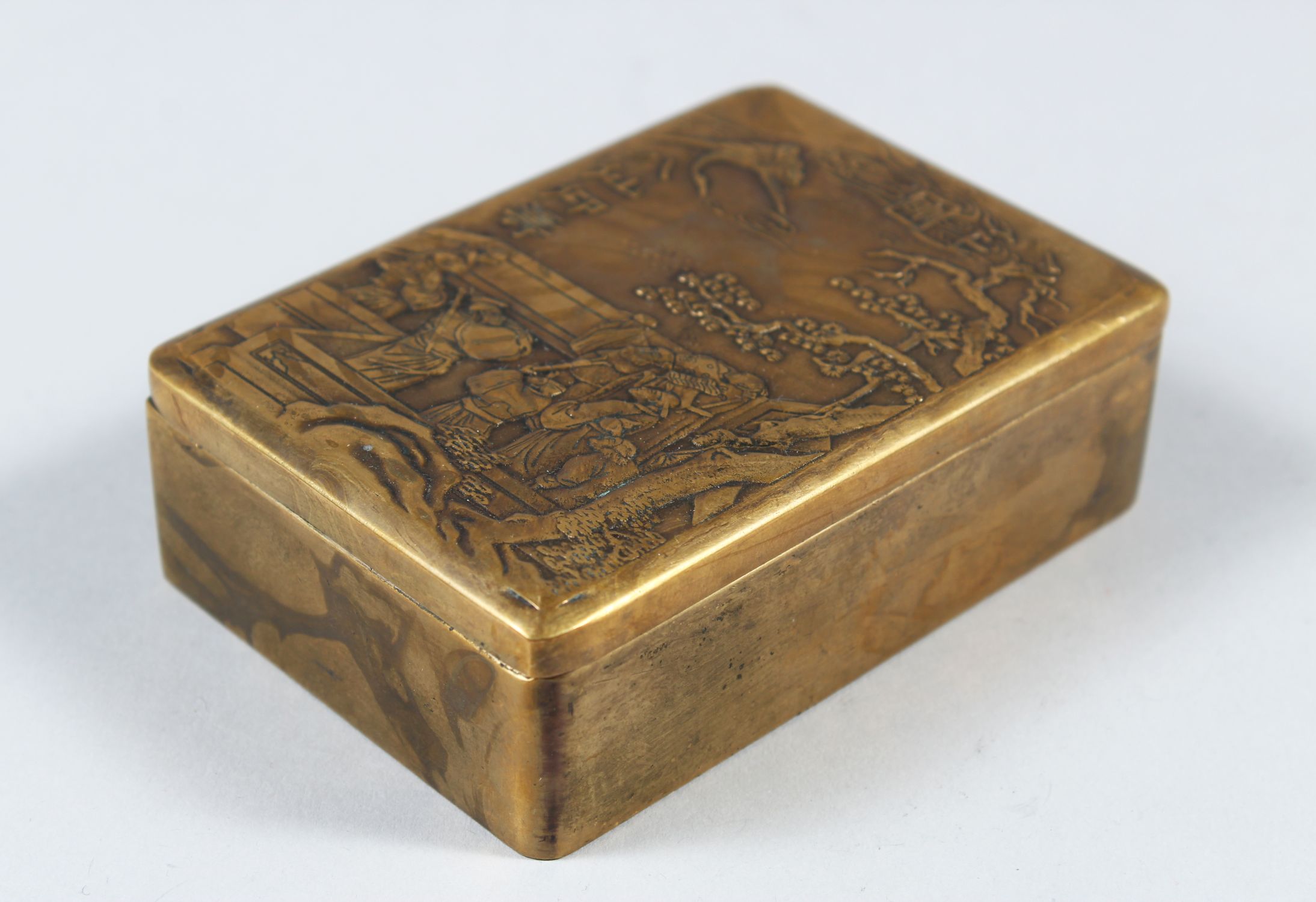 A CHINESE BRONZE INK BOX, WITH CARVED AND SIGNED LID, with scenes of warriors around trees, 10cm