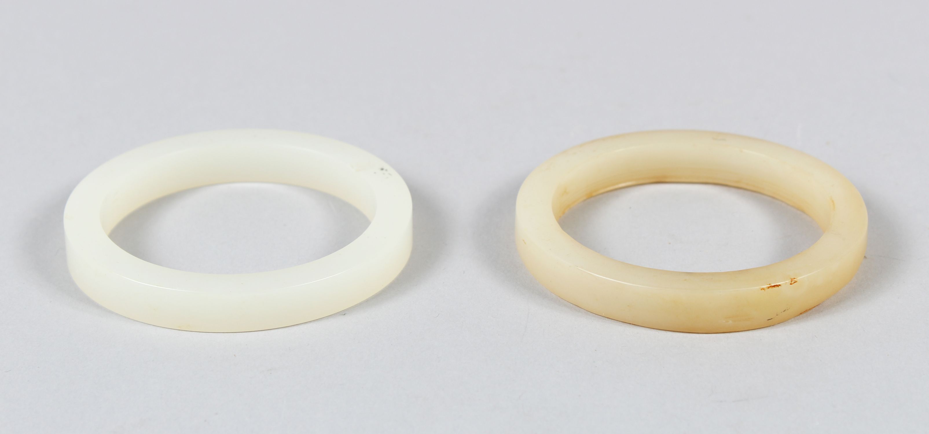 A CHINESE WHITE JADE BANGLE, also another similar jade bangle, 7.5cm diameter.