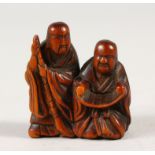 A JAPANESE BOXWOOD NETSUKE, depicting two scholars reading a scroll, artist signed to foot, Meiji
