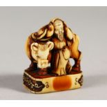 A VERY GOOD JAPANESE EDO PERIOD IVORY SEAL NETSUKE, depicting an Oxen and its attendant, attendant