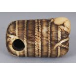 A GOOD QUALITY JAPANESE MEIJI PERIOD STAINED IVORY NETSUKE OF RAT BURROWING INTO A STRAW BALE, 4.1cm