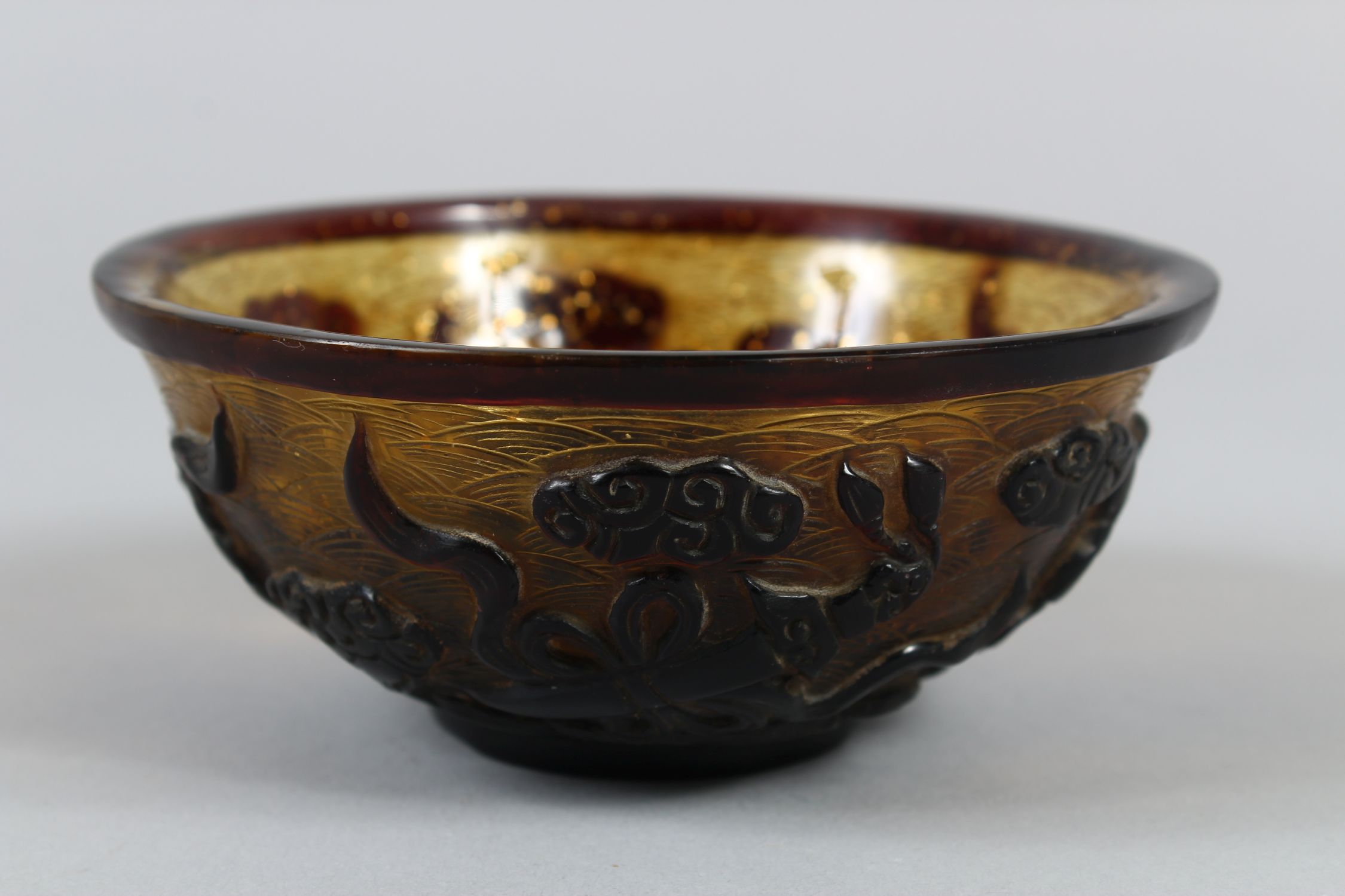 A CHINESE PEKING AMBER GLASS RICE BOWL, with gilt speck inclusions, carved decoration of four Taoist - Image 2 of 7