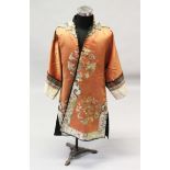 A GOOD 19TH CENTURY CHINESE APRICOT GROUND EMBROIDERED SILK ROBE, decorated with eight roundels.