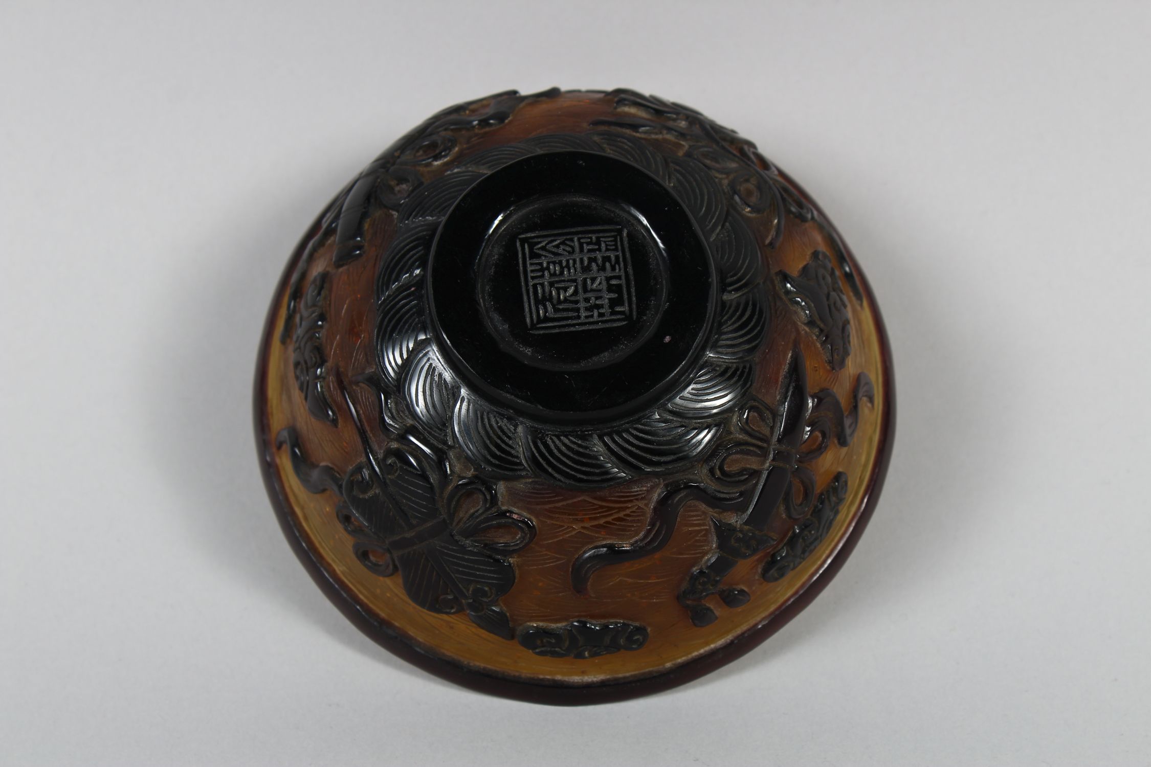 A CHINESE PEKING AMBER GLASS RICE BOWL, with gilt speck inclusions, carved decoration of four Taoist - Image 6 of 7