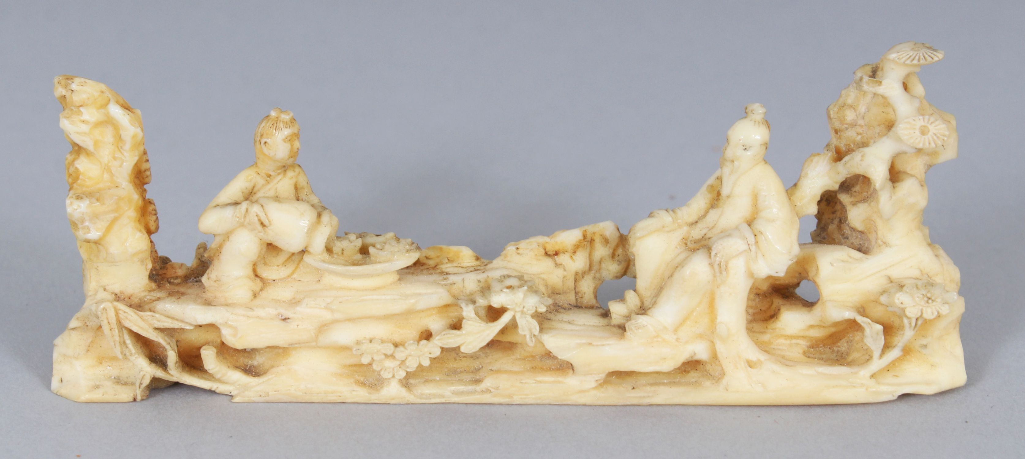 AN UNUSUAL 19TH CENTURY CHINESE IVORY BRUSH REST, carved in the form of a sage and his attendant,