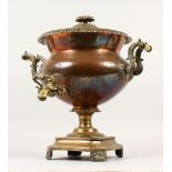 A GOOD REGENCY CIRCULAR COPPER TWO-HANDLED SAMOVAR, on a square base with claw feet. 36cms high.