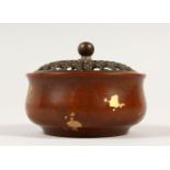 A SMALL CHINESE BRONZE CIRCULAR CENSER, with pierced top and gold splash decoration. 8cms diameter.