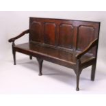AN 18TH CENTURY OAK SETTLE, with a four panel back, curving arms, solid seat, on cabriole front