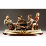 A VERY GOOD CAPODIMONTE PORCELAIN GROUP by MERLI. Four boys playing cards, two cheating, on a wooden